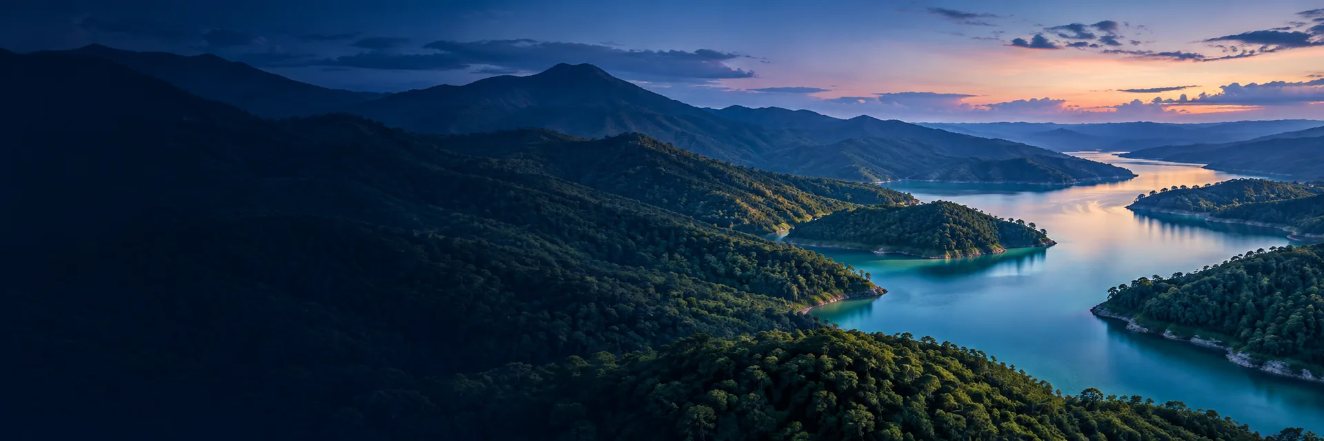 Paisaje de montañas y un lago al atardecer.